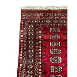 Persian Bokhara rug, red ground and decorated with single row of Gul motifs, multiple band border with geometric design