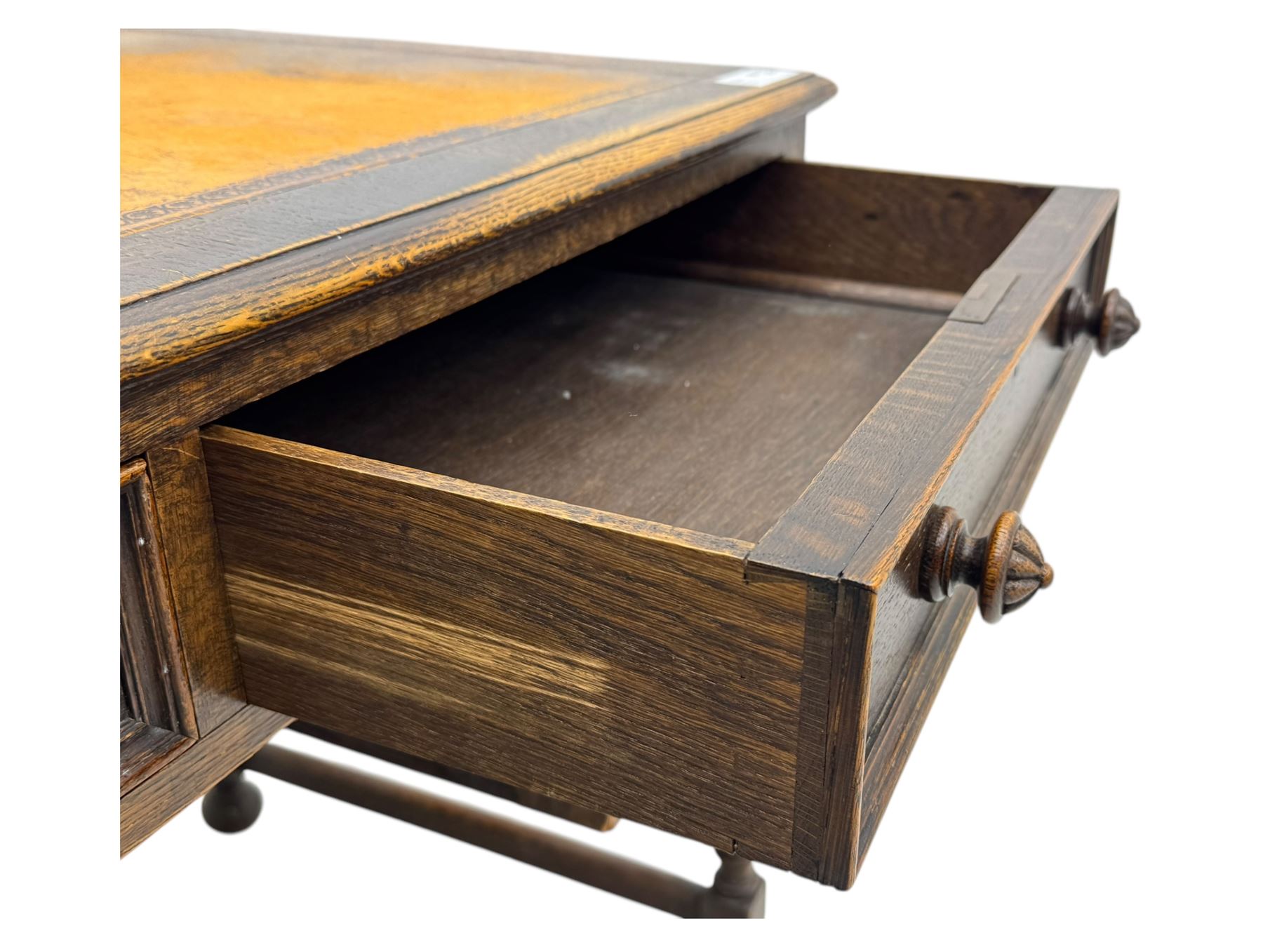 Early 20th century Jacobean design oak desk, with rectangular top inset with worn tooled leather, two frieze drawers over pedestals each fitted with a pair of panelled drawers, turned handles, on carved and fluted tapering legs united by stretchers 