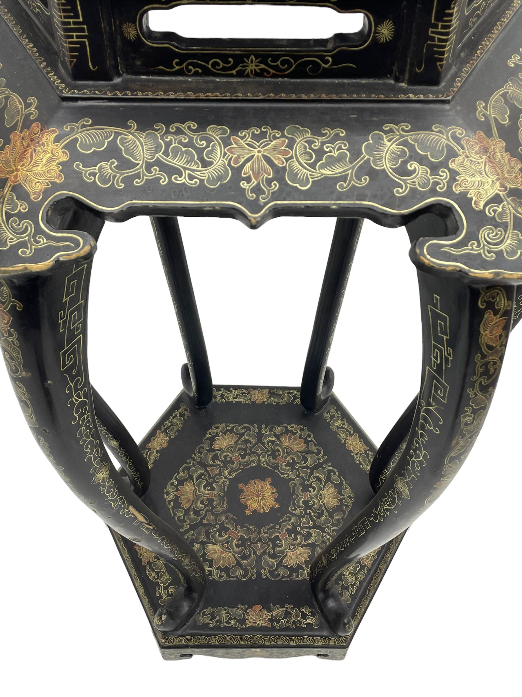 Chinese black lacquer jardinière stand, the hexagonal top painted with traditional landscape scenes within a gilt strung border, the pierced frieze with trailing foliate decoration and geometric patterns, supported on six cabriole supports united by a raised hexagonal base