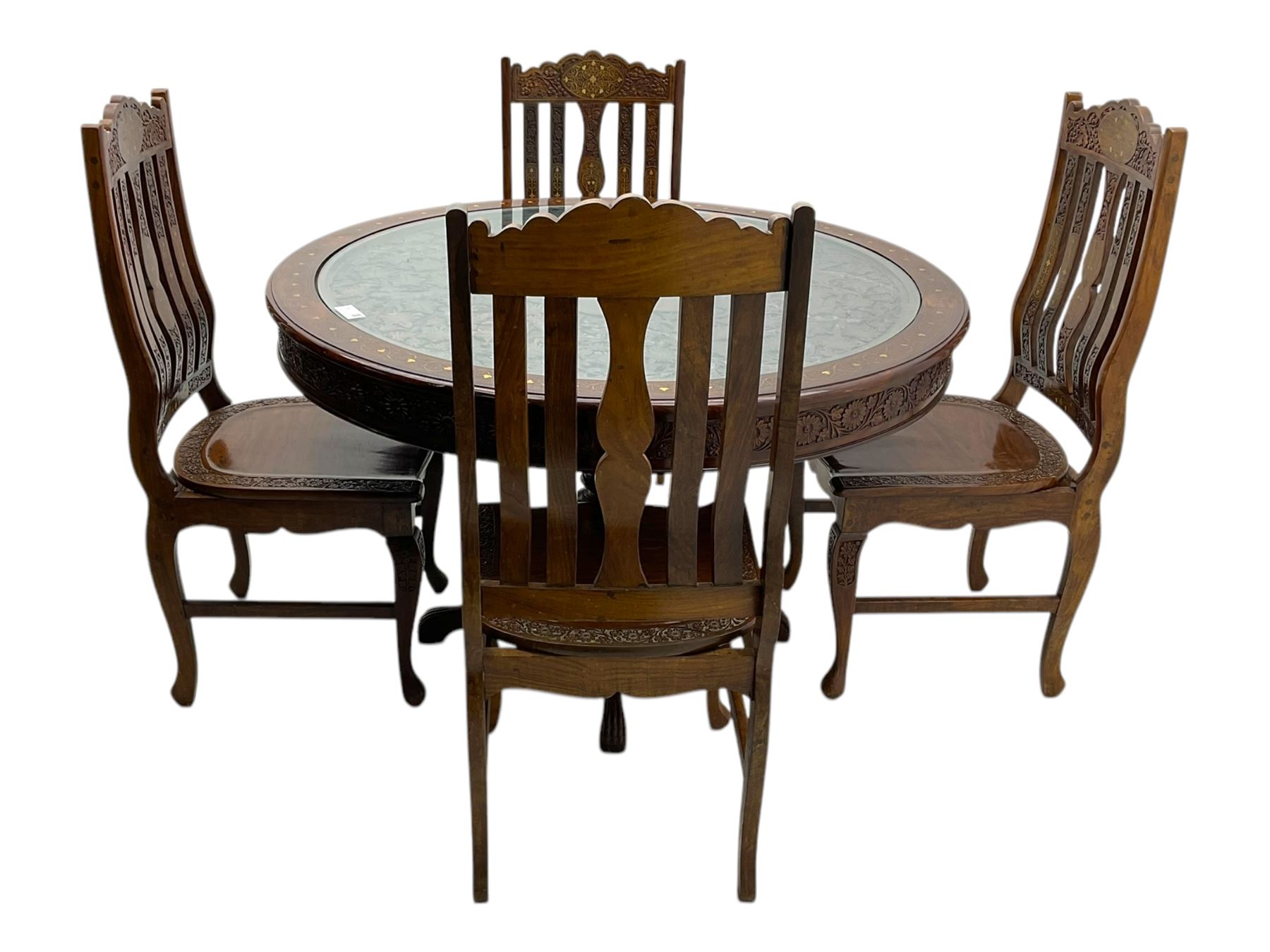 Pakistan carved hardwood brass inlaid circular dining table, and four rail back chairs with saddle seats