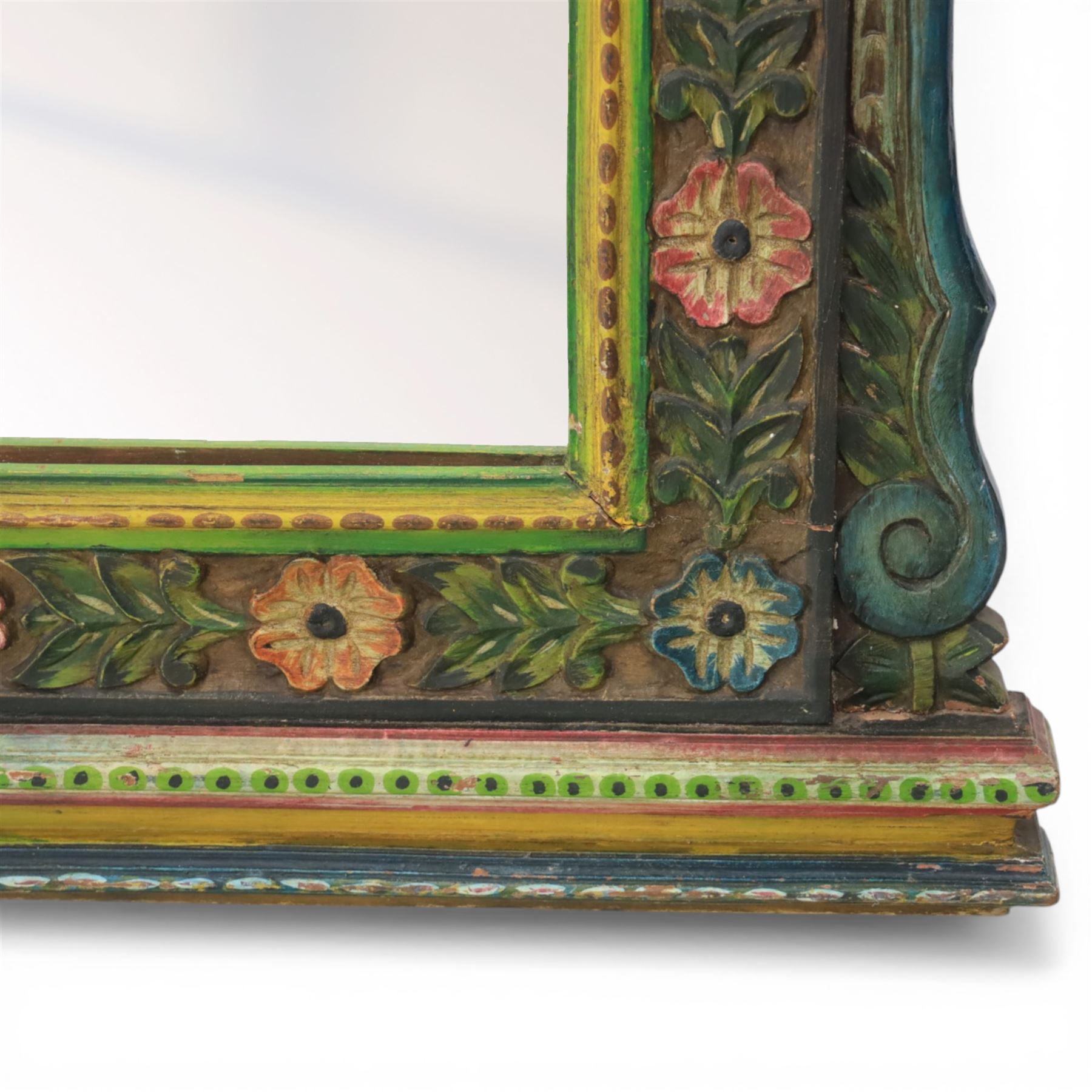 Late 20th century Venetian style polychrome carved wall mirror, arched cresting with central shell motif and scrolling foliate decoration, moulded frame with carved floral borders in relief, enclosing rectangular mirror plate, shaped sides with scroll terminals