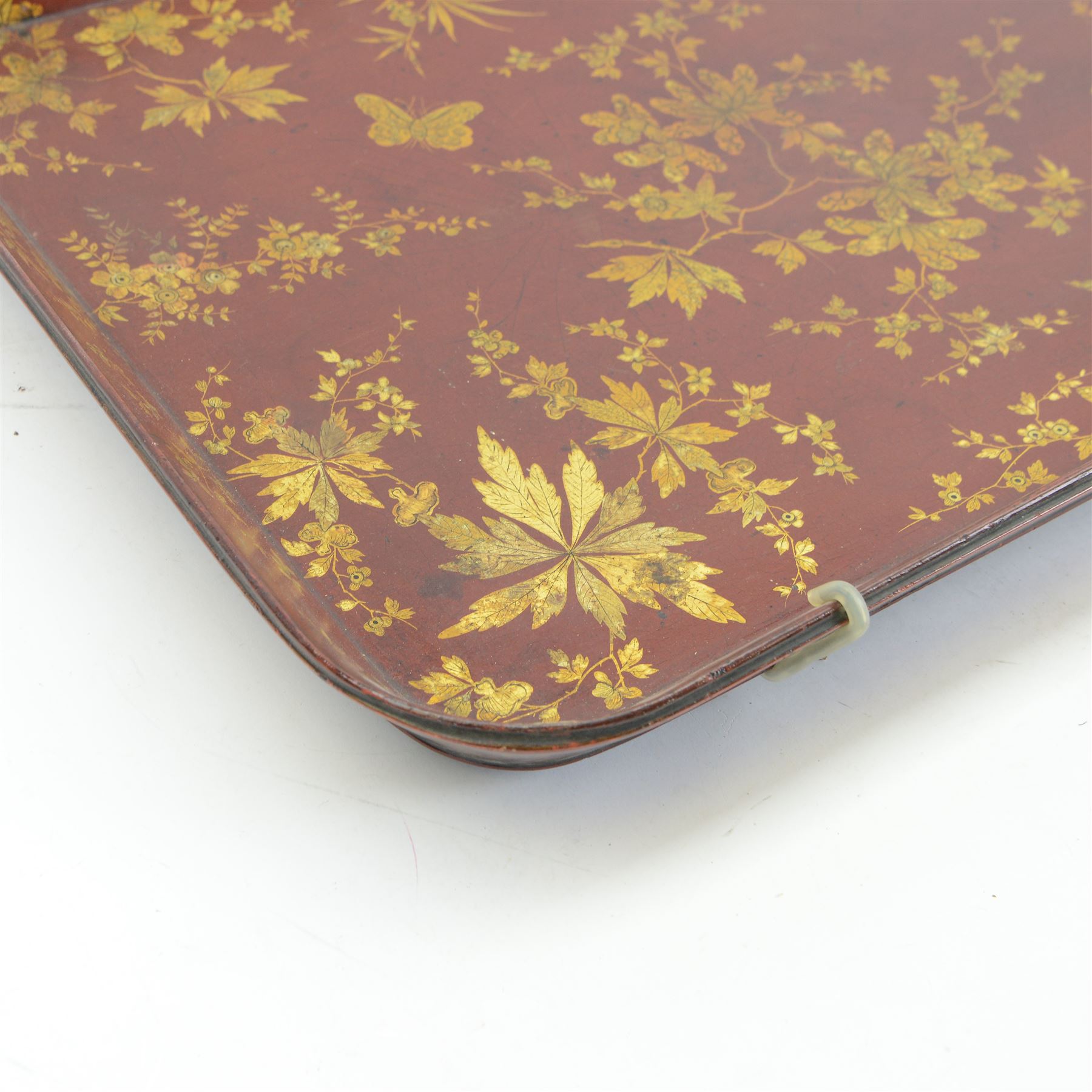 Early 19th century red lacquered papier-mâché tray by Clay of King Street Covent Garden, of rounded rectangular form, painted in gilt with large foliate sprays and butterflies, impressed verso CLAY KING ST COVENT GARDEN, W66.5cm D48.5cm