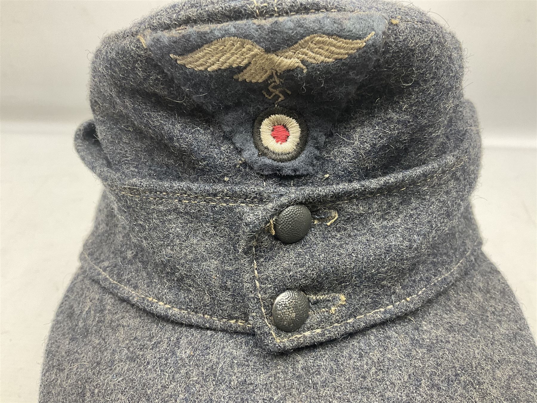 WW2 German Luftwaffe M43 field cap with triangular cloth eagle and roundel badge; marked '1944 ?/0501/0015 57'