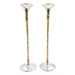 Pair of modern silver candlesticks by Stuart Devlin, the tapering parcel gilt stems with signature textured detailing, each supporting a fluted candle holder and upon a spreading circular foot, hallmarked Stuart Devlin, London 1973, H25cm