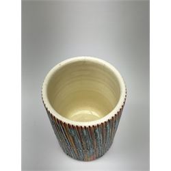 A Poole Pottery Delphis vase, shape 83, with textured effect in merging tones of red, yellow and blue, with printed mark beneath, H15cm.