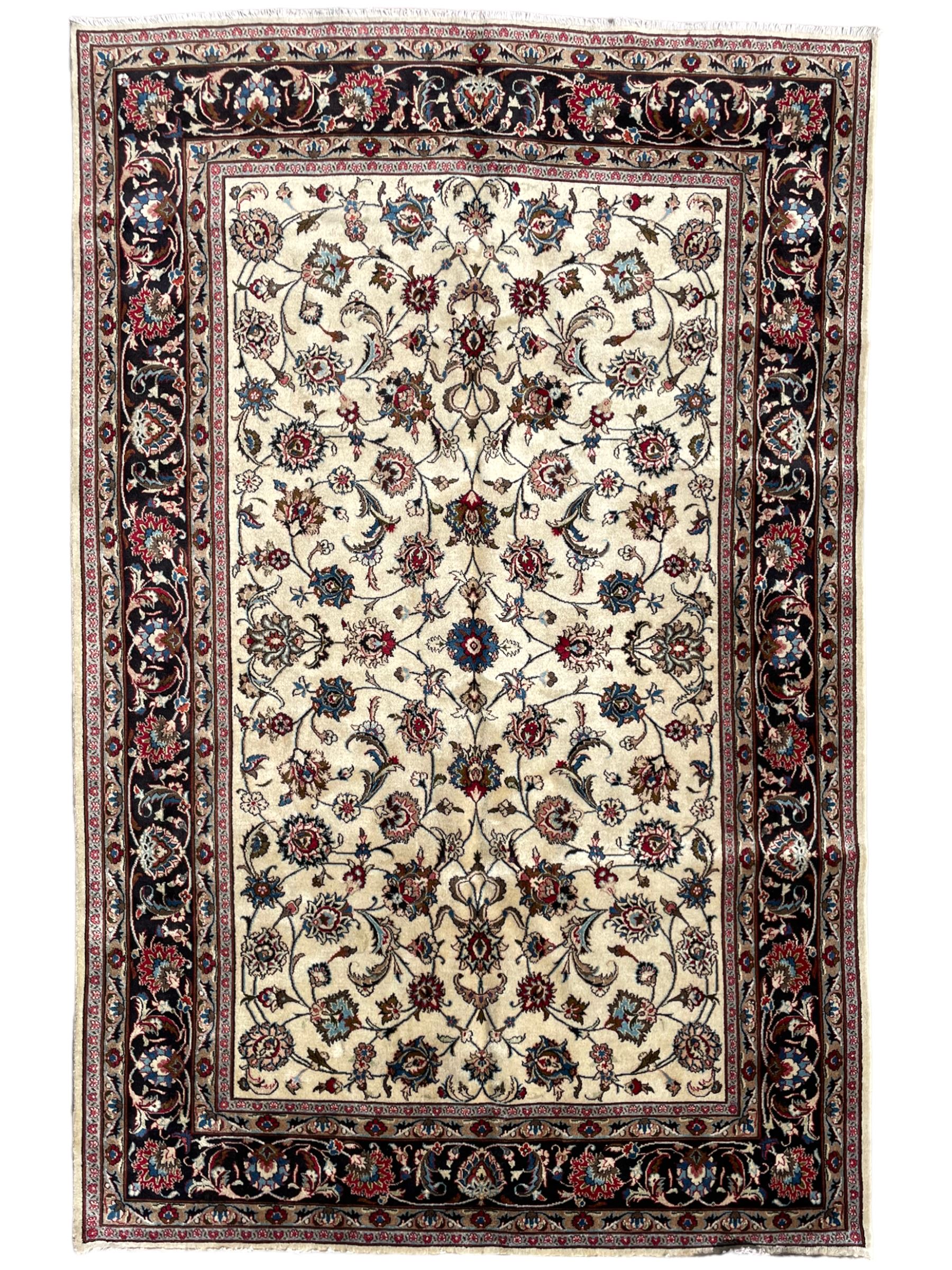 Persian ivory ground rug, the field decorated with interlaced and scrolling foliate with palmettes, the dark indigo border with stylised plant motifs surrounded by scrolled branches