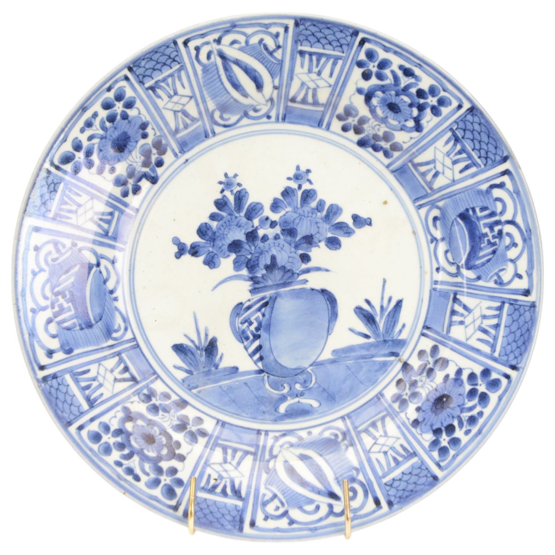 Two Japanese Edo period Ko Imari blue and white porcelain chargers, each decorated in the Kraak style with urns issuing peonies, pine and prunus, within panelled borders containing flowers, tress and precious objects, each approximately D 31.5cm