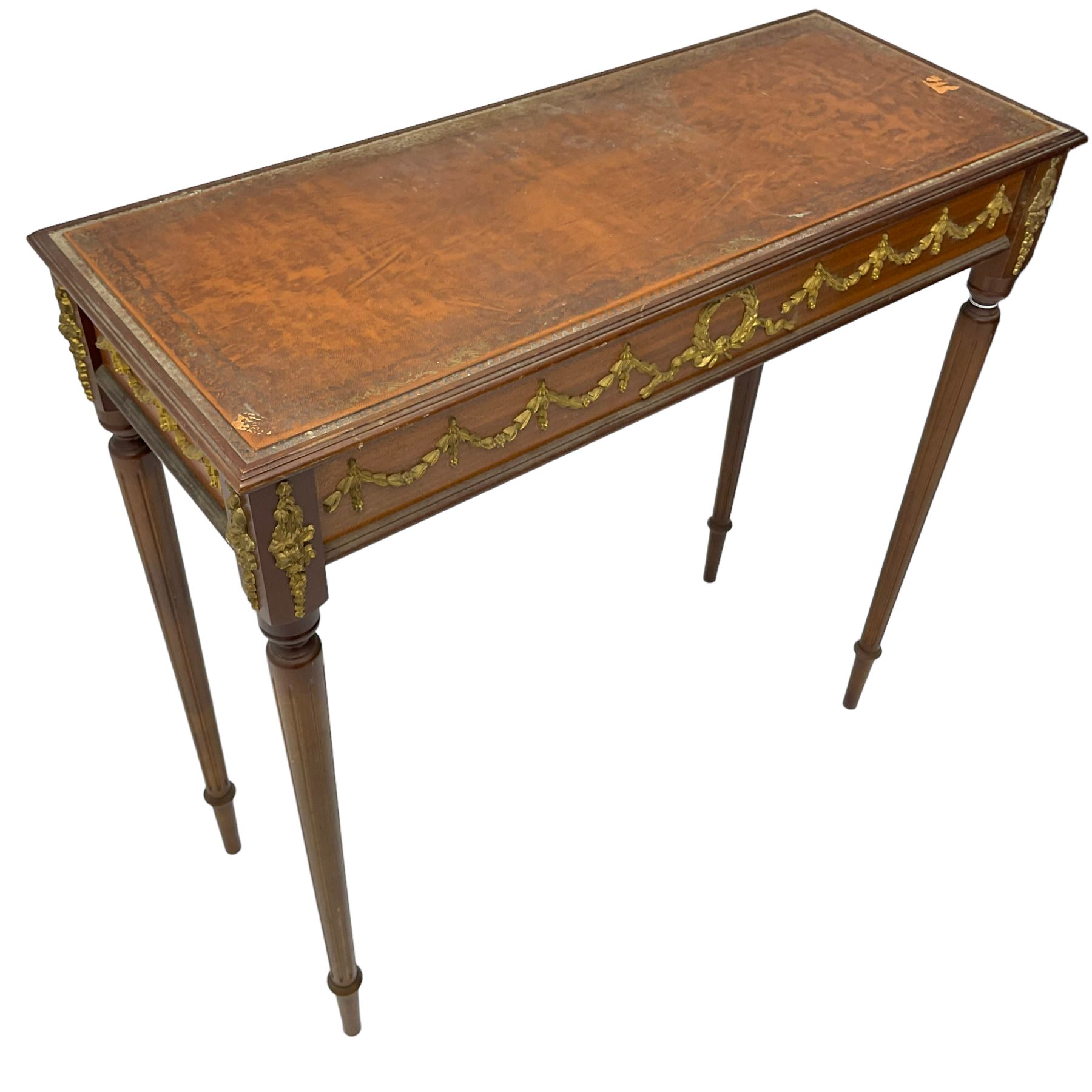 Early 20th century mahogany side table, inset amber leather surface, frieze decorated with applied gilt festoons and central wreath, on tapering fluted supports