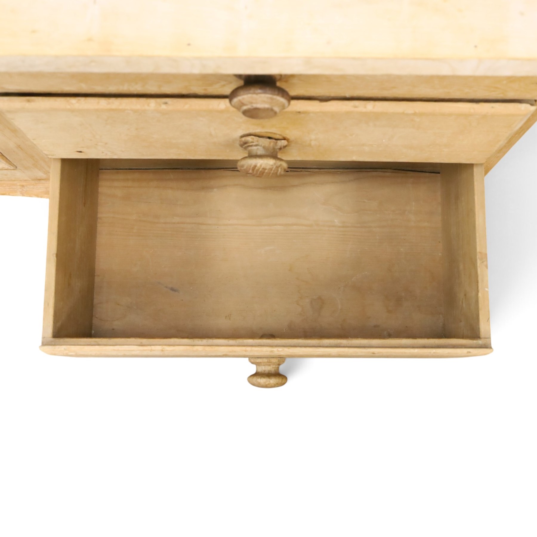 Victorian stripped pine dresser base with plate rack, the four-tier plate rack with supporting rails and hooks, the inverted-breakfront base fitted with seven assorted graduating drawers surrounding a recessed cupboard, on compressed bun feet with castors