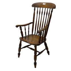 Early 19th century elm farmhouse armchair, the shaped eared cresting rail over tall spindle back, dished seat on turned supports united by H stretchers