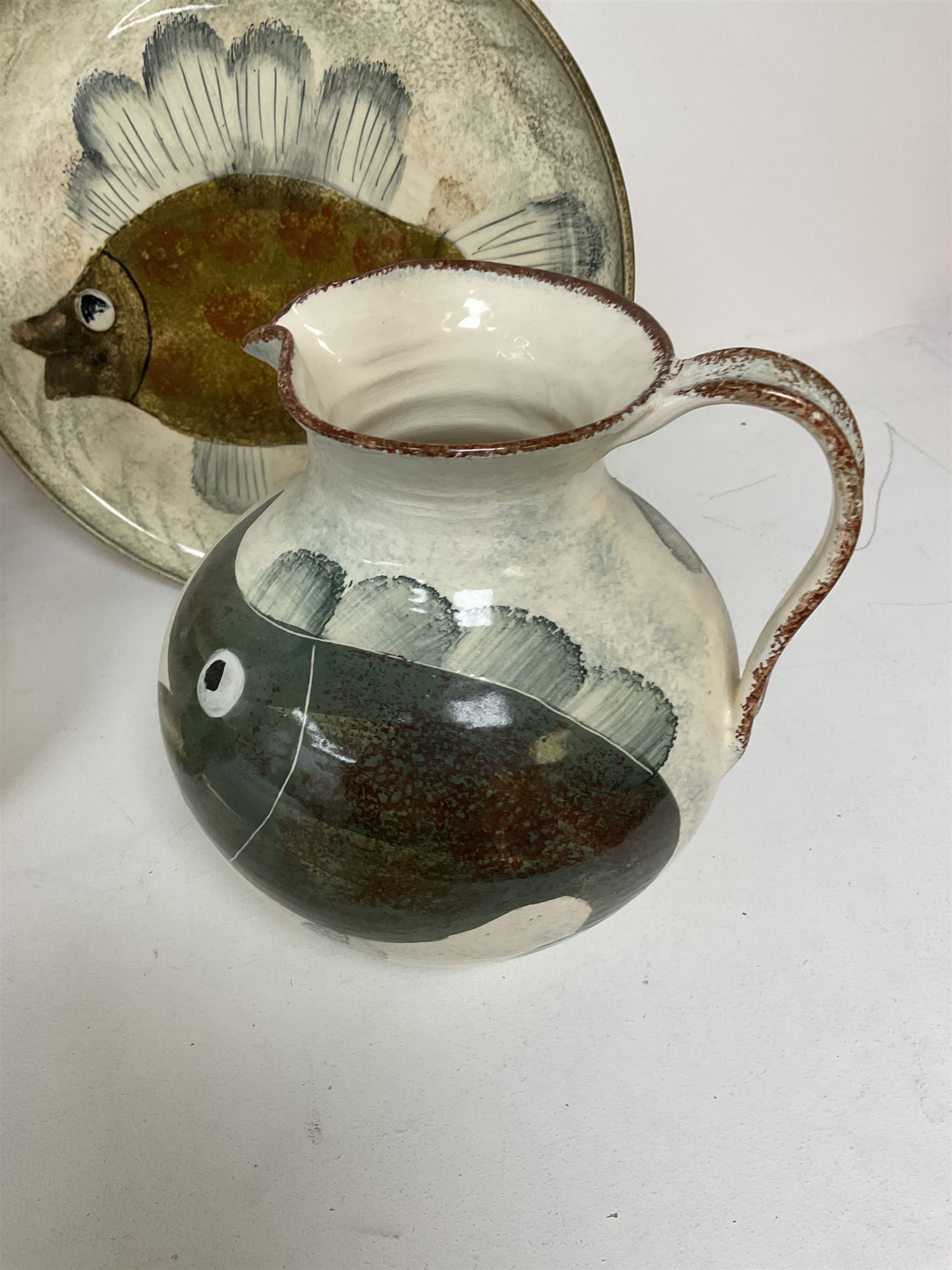 Collection of Yorkshire Moorlands Pottery, comprising two large circular dishes and three jugs, decorated with various fish, flowers, red grouse and cockerel