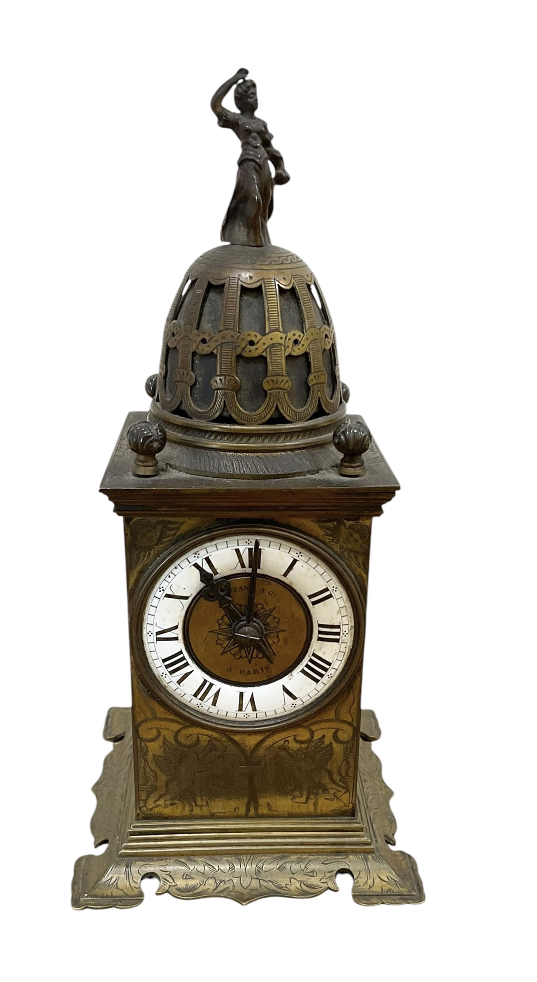 Tiffany- early 20th century brass cased 8-day mantle clock, rectangular case with engraved images taken from classical & mythological fables, with an open strapwork dome, finials to the corners and a cast figure of a standing maiden, case raised on a splayed base with acanthus engraving, enamel dial with Roman numerals, minute markers and steel hands, dial centre engraved Tiffany & Co Paris, twin train French movement with a platform escapement wound from the rear, baseplate of case stamped with the serial numbers 4372 & 5652. With key. 
Provenance from Chatsworth House, Derbyshire.