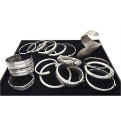 Collection of twelve silver bangles and two white metal bangles