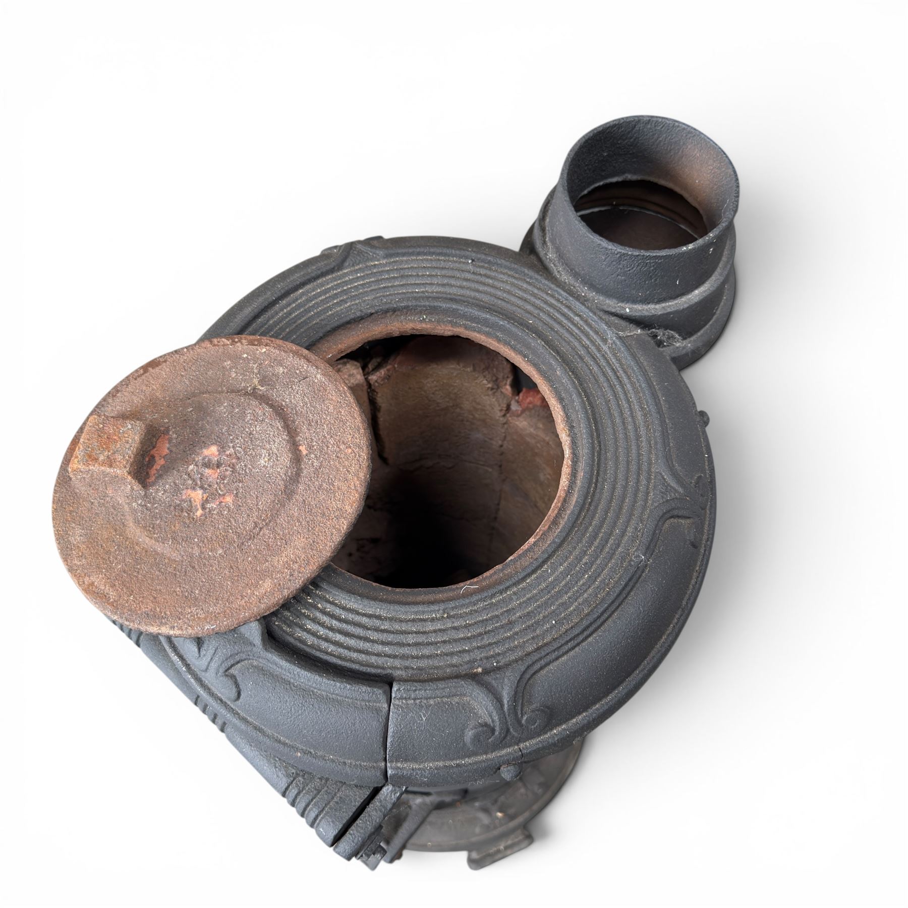 Late Victorian cast iron stove of small proportions, decorated with scrolls and central rosette to the top