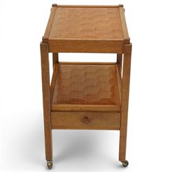 Acornman - oak two tier tea trolley, rectangular adzed top and lower section, with drawer raised on square supports terminating in castors, with carved acorn signature, by the workshop of Alan Grainger of Brandsby