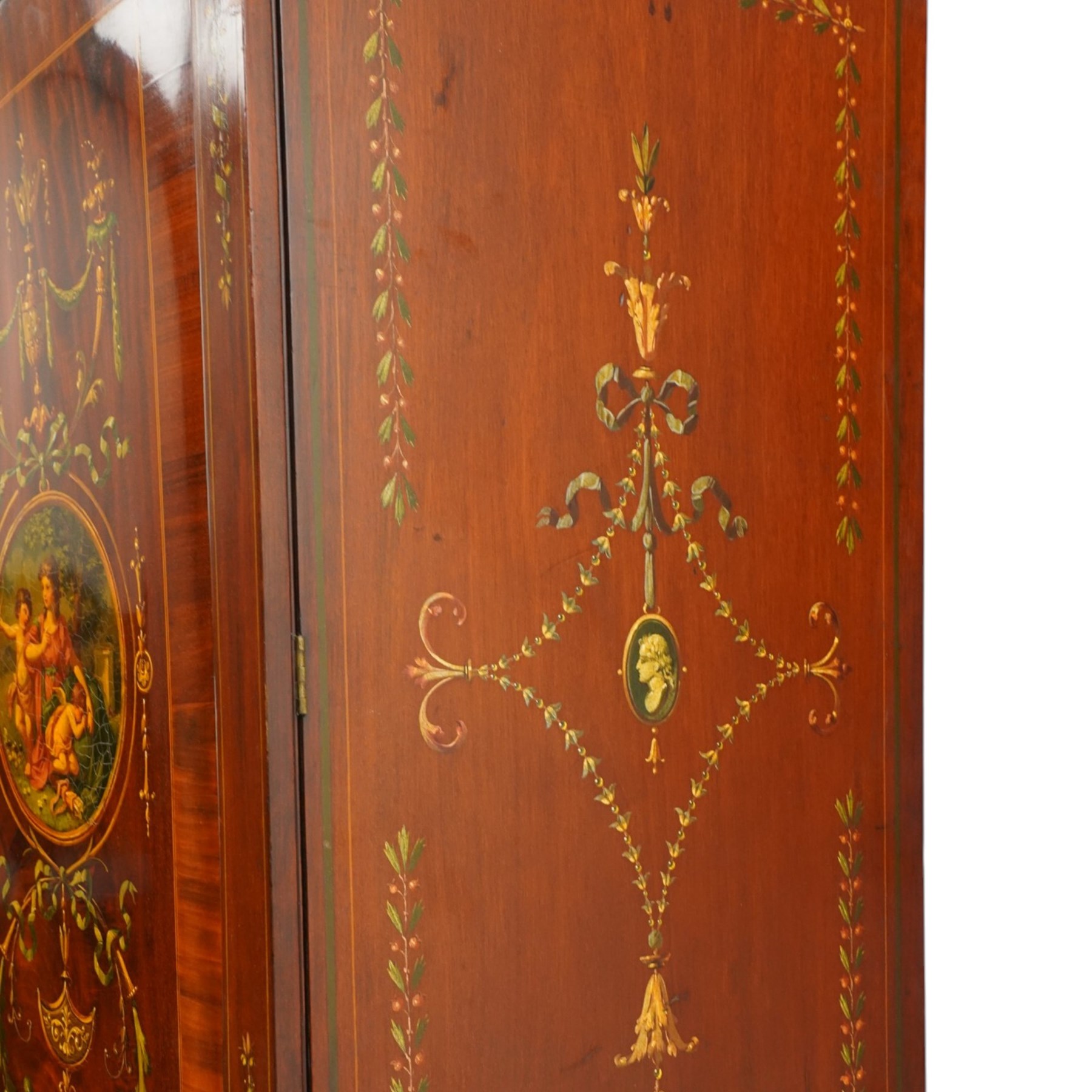 19th century French Louis XVI design mahogany and polychrome painted gentleman's press wardrobe - projecting cavetto cornice with urn and bellflower painted frieze, the twin doors with classical figural medallions surmounted by urns and festoon decoration with scrolling acanthus leaves, enclosing five sliding trays, the base fitted with two short over three long cock-beaded drawers, the facias painted with interlocking swags and garlands of bouquets with recumbent lion brass handle-plates, lower reeded edge on turned feet
