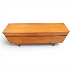 Mid-20th century teak sideboard, rectangular top above four frieze drawers with recessed handles, flanked by two cupboard doors with fall front central media cupboard