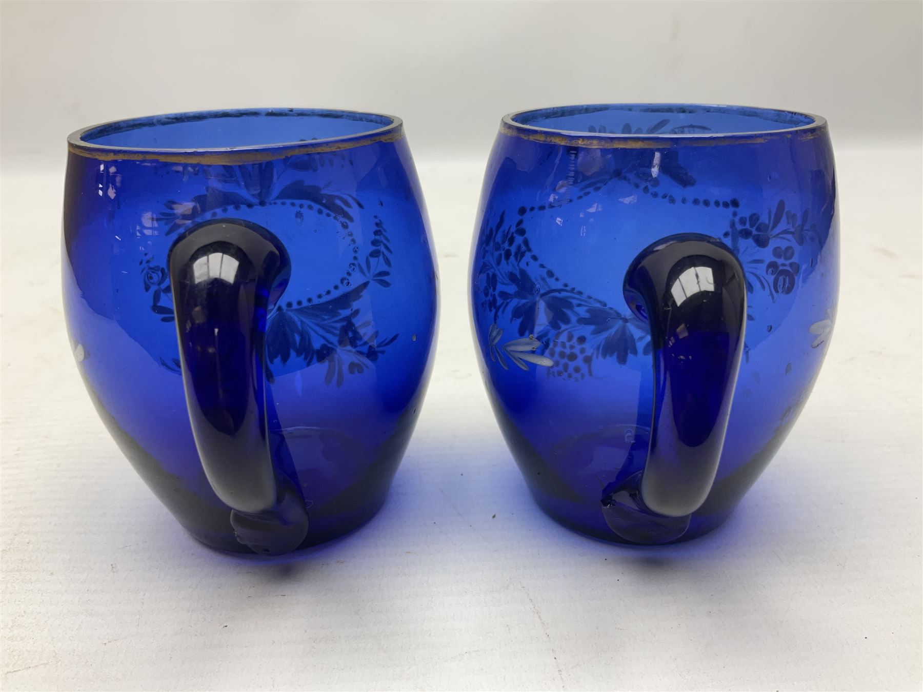 Pair of Victorian cobalt blue glass cups with gilt and painted decoration, entitled Hope's the Balm of Life and Love me as I Love Thee, H8.5cm