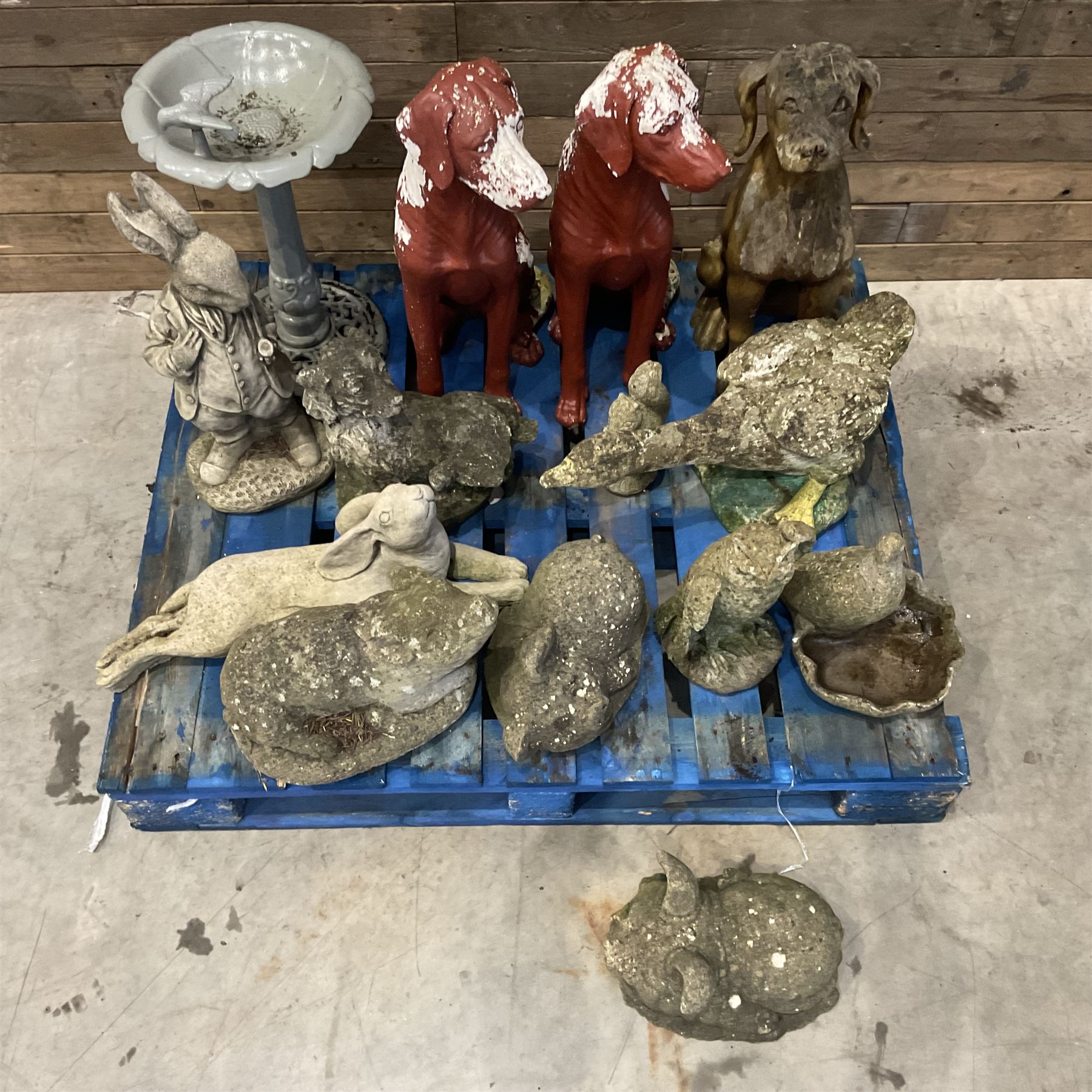 Various cast stone and composite garden ornaments, to include Peter Rabbit, goose, pigs, dogs, dog with wheelbarrow, painted metal bird bath and other, on two pallets