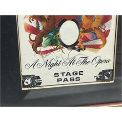 Queen - A Night At The Opera; fabric Stage Pass signed by all four members Freddie Mercury, Brian May, Roger Taylor and John Deacon 14 x 9.5cm; mounted in a modern frame with print of the band during a performance