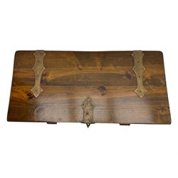 Mid-20th century carved hardwood chest, the rectangular hinged top with decorative strap hinges, the front and sides deeply carved with medieval-style jousting knights, heraldic shields, and architectural elements, raised on shaped block feet