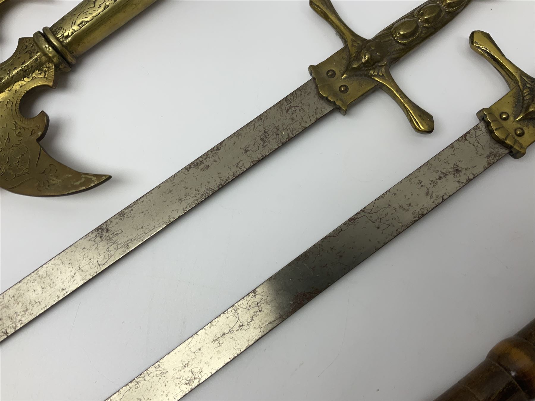 Near pair of short swords each with slightly curving 41cm fullered steel blade and all brass H-shaped hilt L52cm overall; plaited black leather whip; and reproduction pair of brass hilted swords, brass halberd blade and mace (7)