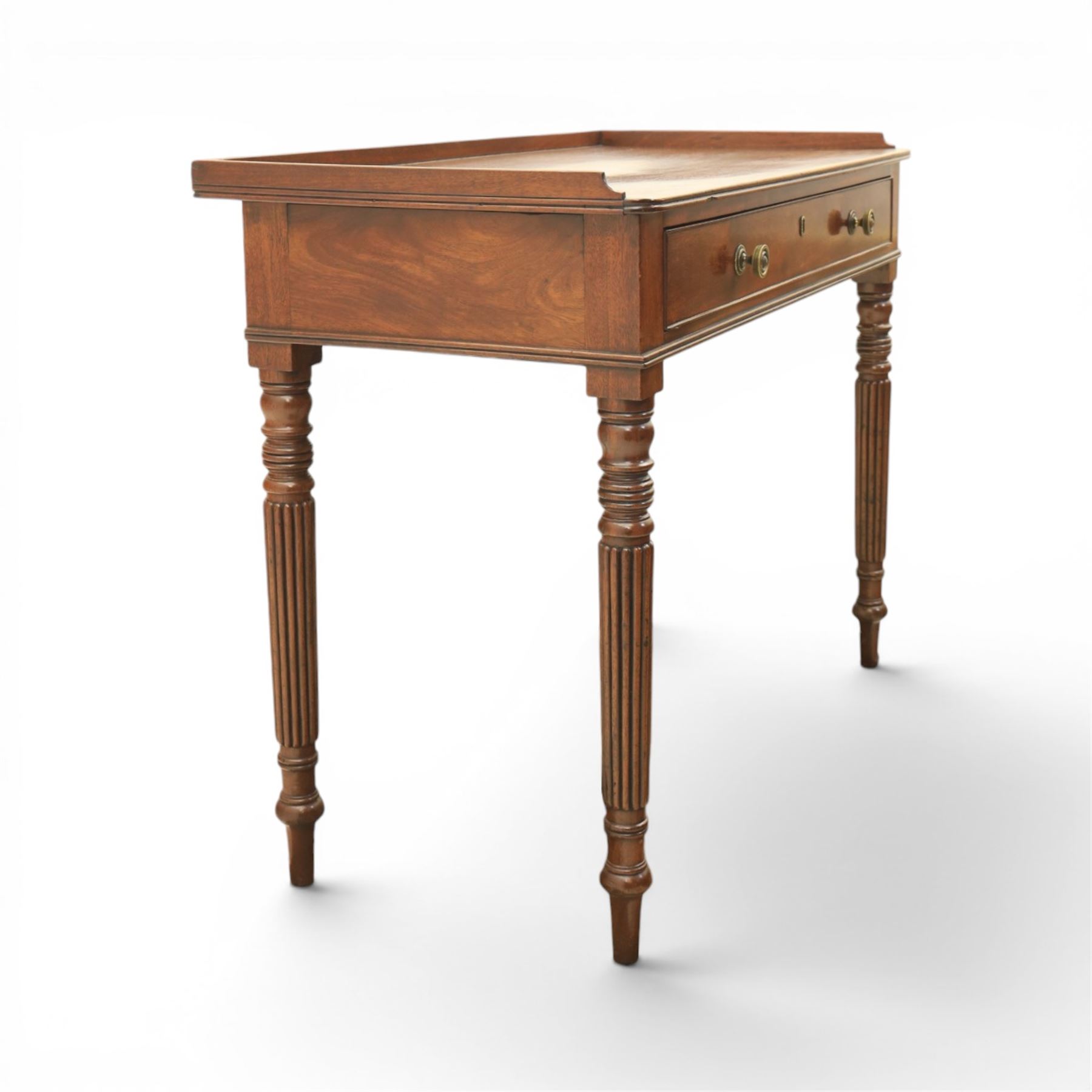 Early 19th century mahogany dressing table, rectangular top with three quarter gallery, frieze drawer with two brass knobs, stamped 'Gillow', raised on turned and reeded supports 