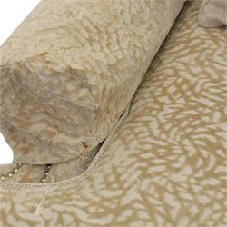 Late 20th century wingback armchair and matching footstool, upholstered in beige embossed fabric with brass stud edging, on cabriole legs and splayed rear legs, together with a matching footstool on turned supports terminating in brass castors (Stool H 42cm, W 75cm, D 47cm)