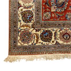 Persian Tabriz hand-knotted carpet, crimson field densely decorated with scrolling floral and foliate motifs, enclosed by a broad cream principal border with repeating floral medallions and multiple guard stripes