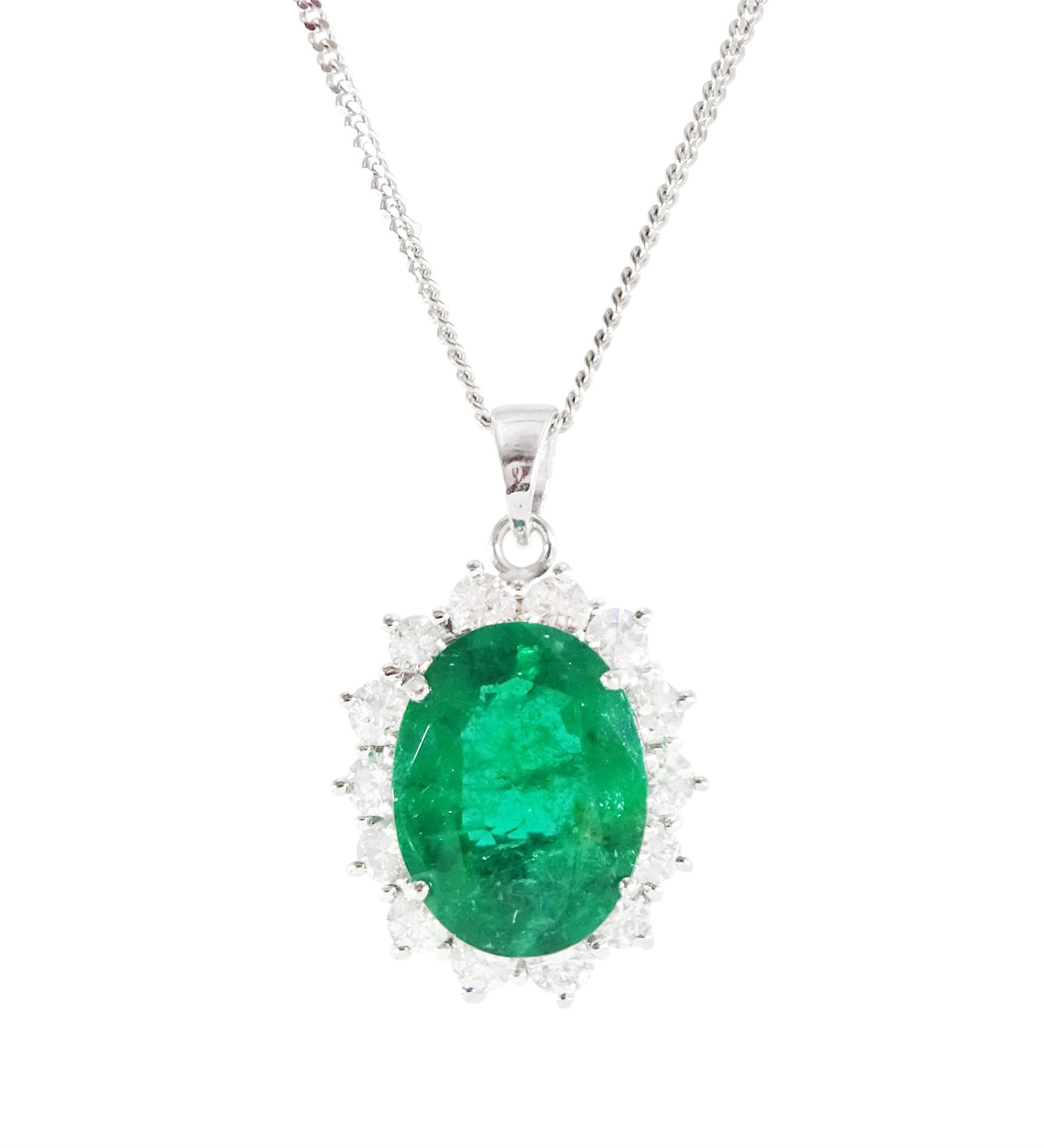 18ct white gold emerald and diamond pendant necklace, single oval cut  emerald of approx 3.25 carat, surrounded by fourteen round brilliant cut diamonds, on a fine link chain necklace, hallmarked, total diamond weight approx 0.50 carat