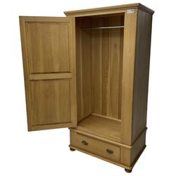 Waxed pine single wardrobe, panelled door enclosing hanging rail, single drawer fitted to base, on compressed bun feet