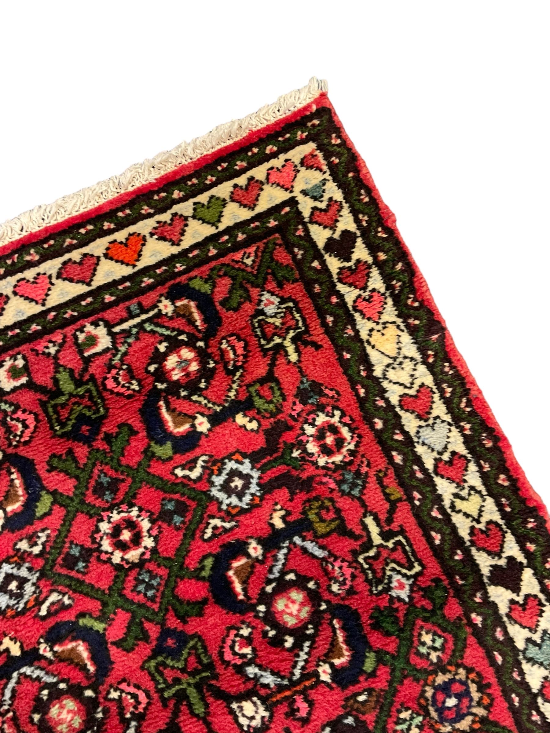 Persian red ground runner, decorated with large Herati motifs and shaped central medallion, the guarded border decorated with repeating heart motifs