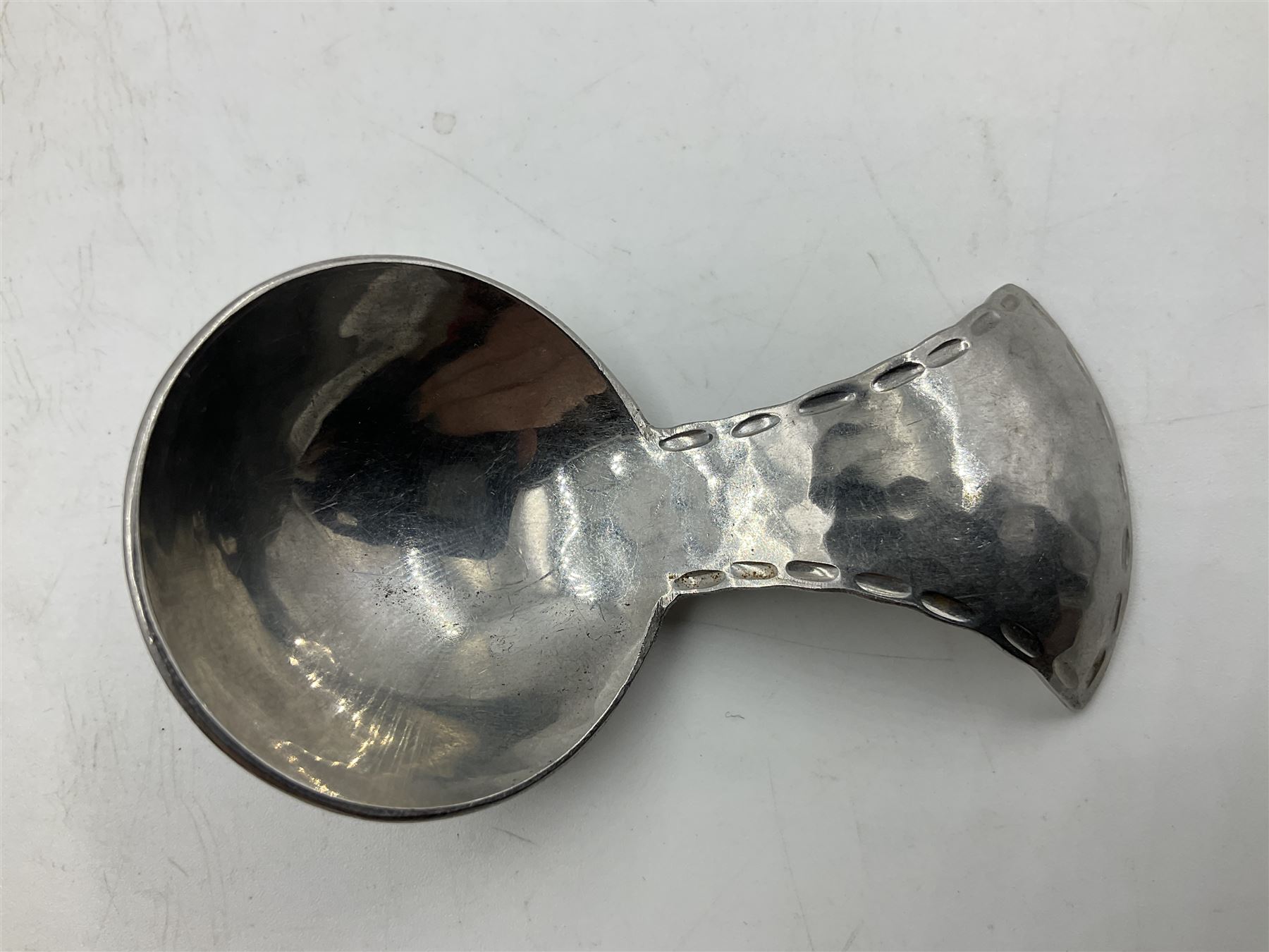 Keswick School of Industrial Arts (KSIA), Arts and Crafts hammered steel Staybrite caddy spoon, L6.5cm, and dish with engraved fern decoration to centre, D11.5cm, both with impressed marks beneath