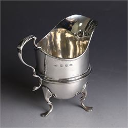 Late Victorian silver helmet shaped cream jug, with acanthus capped handle and upon three pad feet, hallmarked Birmingham 1898, maker's mark worn and indistinct, probably T Beardsmore, H10cm
