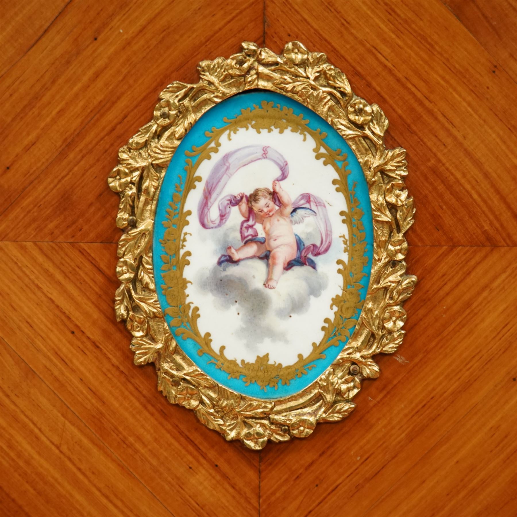 Late 19th century French Louis XV style kingwood and ormolu mounted bonheur du jour, the upper section with a pierced three-quarter gallery over a pair of cupboard doors inset with Sèvres-style porcelain portrait plaques, enclosing a shelved interior over two short drawers, the serpentine top and apron richly mounted with gilt-bronze foliate and scroll motifs, single frieze drawer below on cabriole supports with acanthus cast sabots
