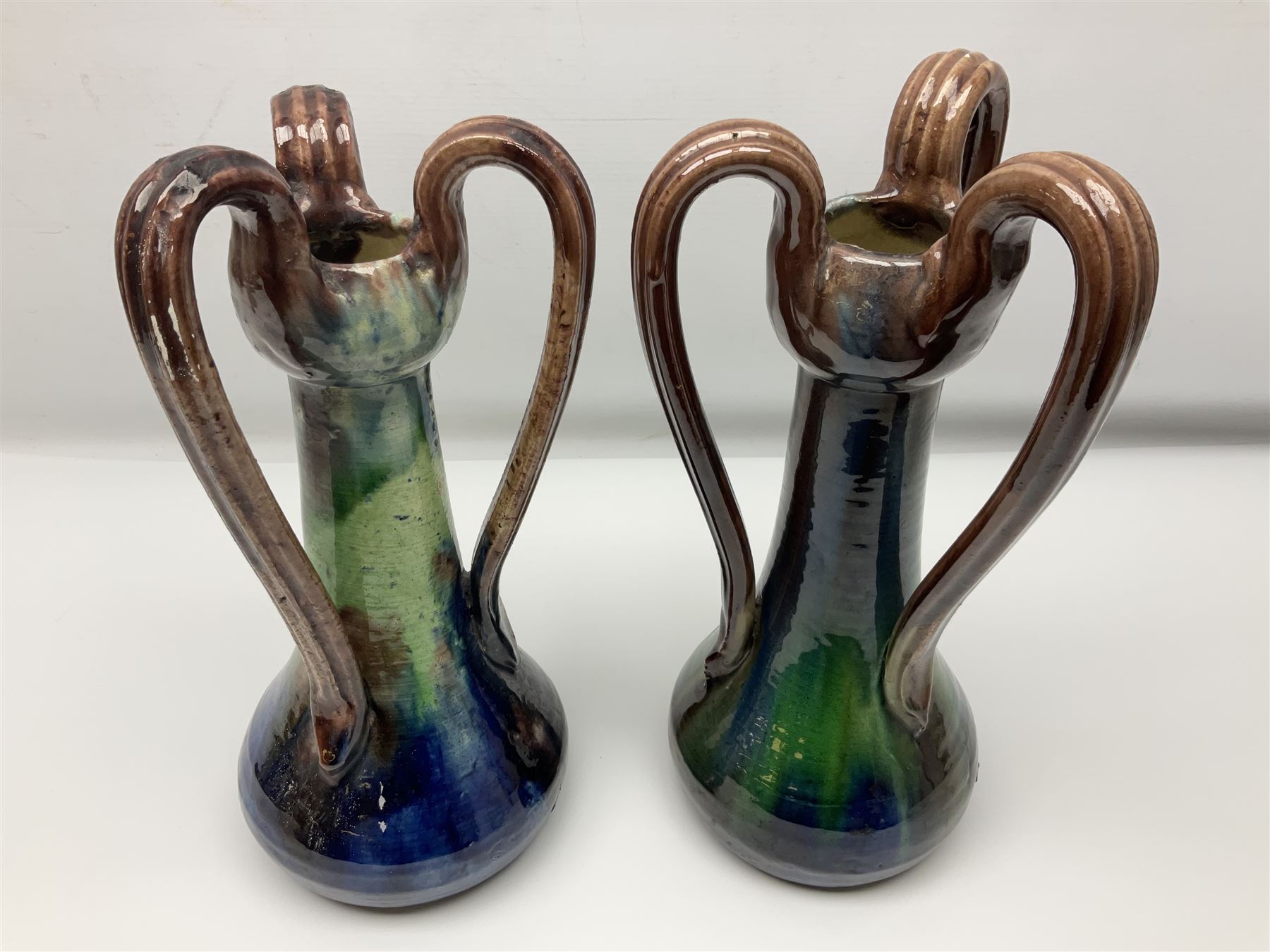 Pair of Art Nouveau style vases, probably Belgian, each with merging blue, brown and green decoration and three handles, impressed LSV beneath, H32cm