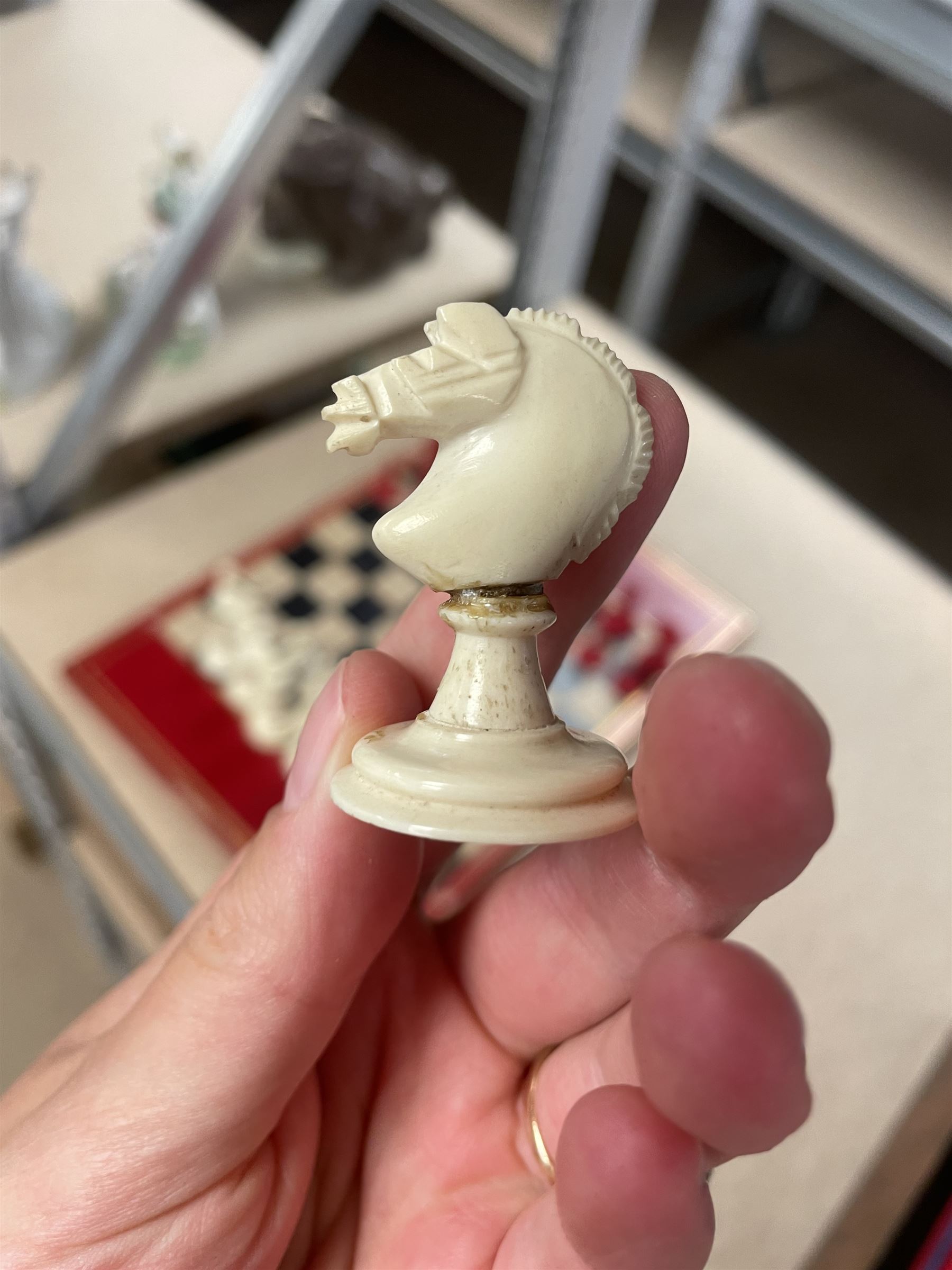 19th century walnut and brass bound games compendium box, painted to enhance the grain, of rectangular form, the hinged opening cover with rounded sides, central brass cartouche with engraved lion crest, and brass riveted straps, opening to reveal a red leather and blue silk lined compartmented interior, with fold-down games board, and lift-out tray containing playing cards, ebony turned dice towers, white and red stained bone draughts, and chess pieces, ivory dice, and ivory and ebony whist markers, and brass bezique board, cribbage board and markers, H15cm W32cm D24cm
This lot has been registered for sale under Section 10 of the APHA Ivory Act