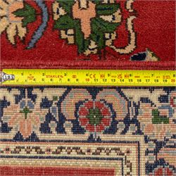 Kashan design wool runner, red field decorated with repeating floral medallions, palmettes and scrolling foliate motifs, enclosed by cream floral border and fringed ends