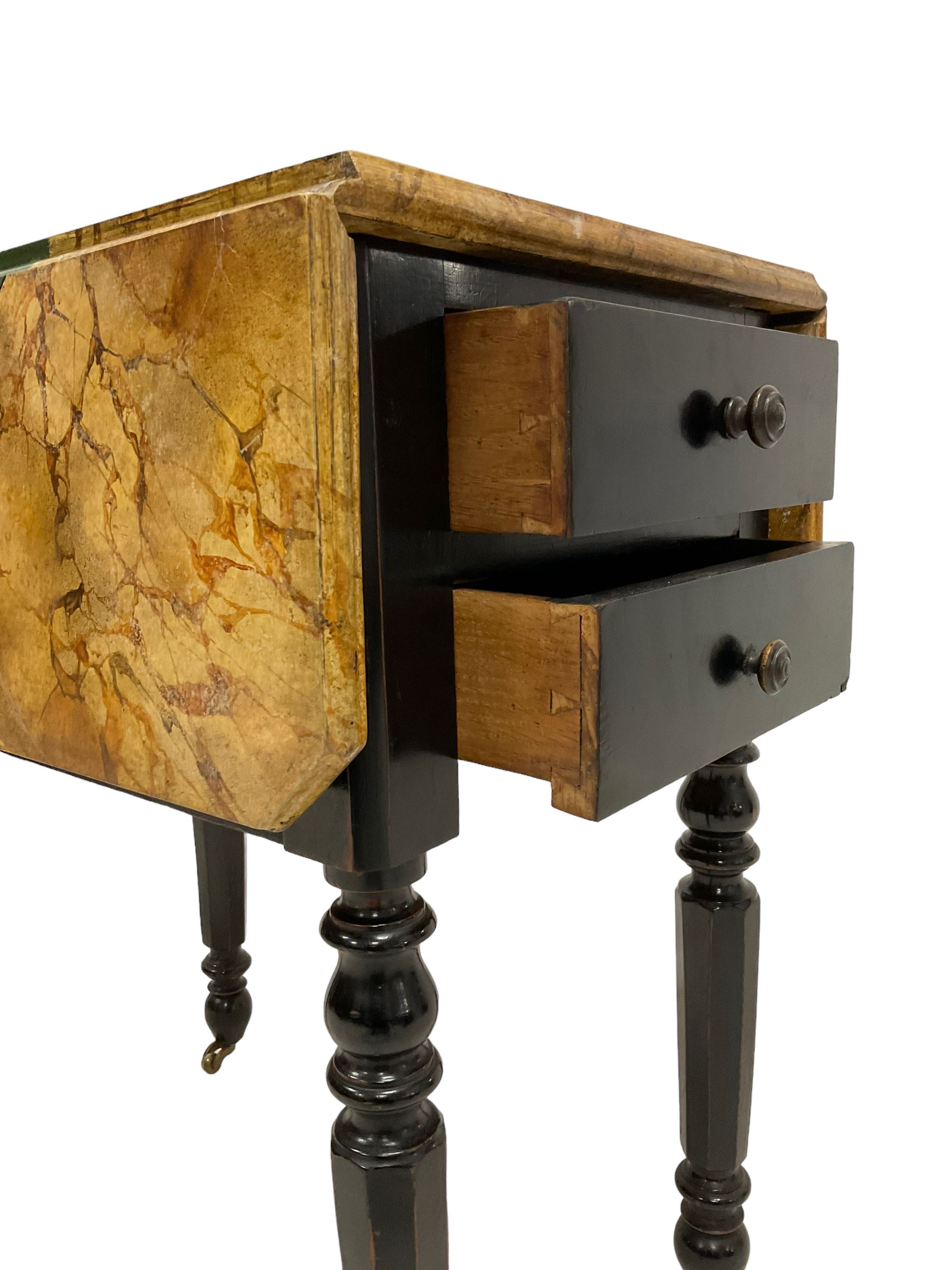 Victorian ebonised drop-leaf pot cupboard with later trompe l'oeil painted top, depicting marbled surface with baize cloth, playing cards and pencil, fitted with two drawers to one end and cupboard to the other with marble inset, on turned and faceted supports with brass castors