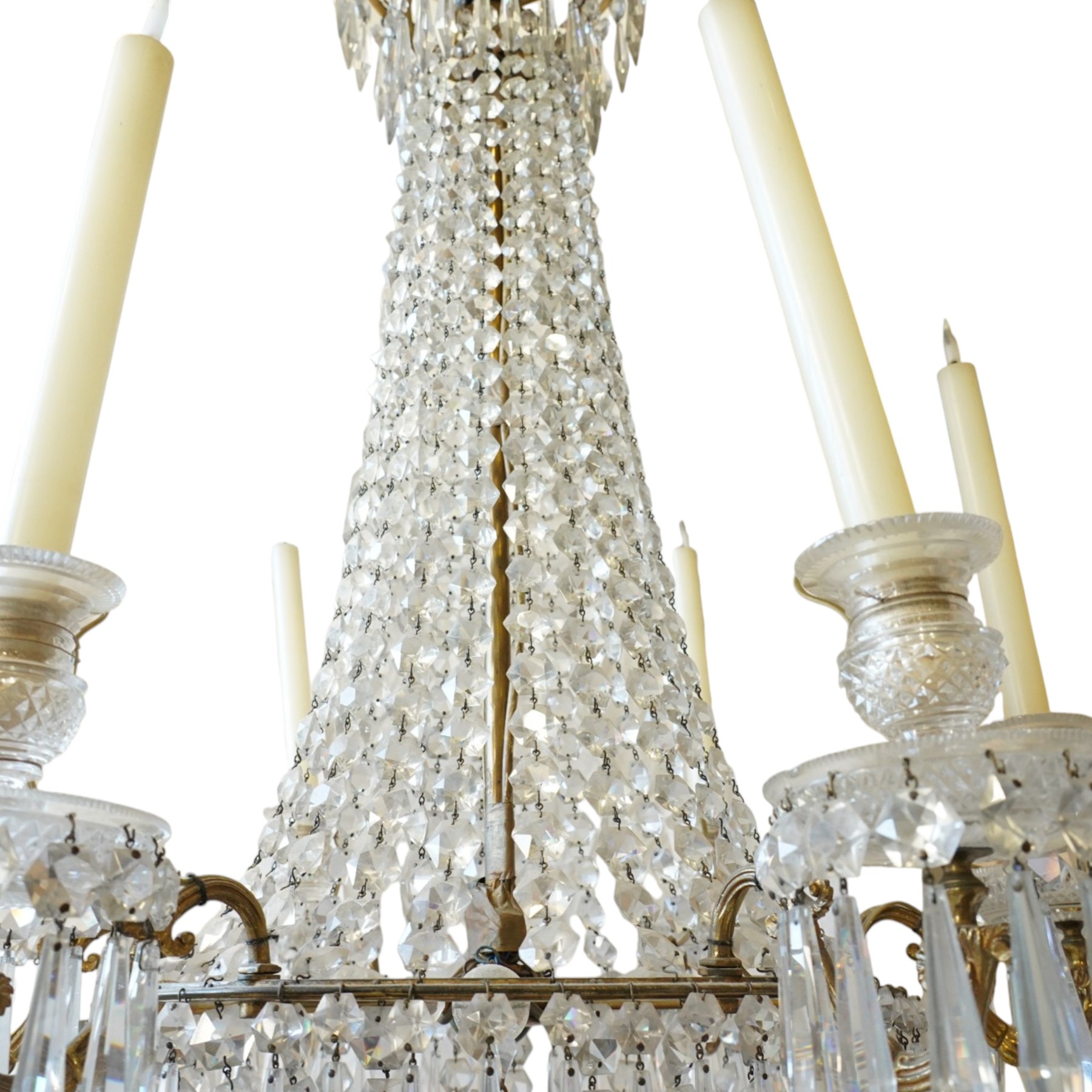 Regency Country House cut-glass and ormolu six light chandelier, the outer shaft with ormolu foliate moulding hung with octagonal and drop pendants, the impressive central shaft with cascading drops of cut-glass, the scroll branches with hob-nail cut candle holders and wax pans, with central similarly cut terminal
Provenance: property of a nobleman
