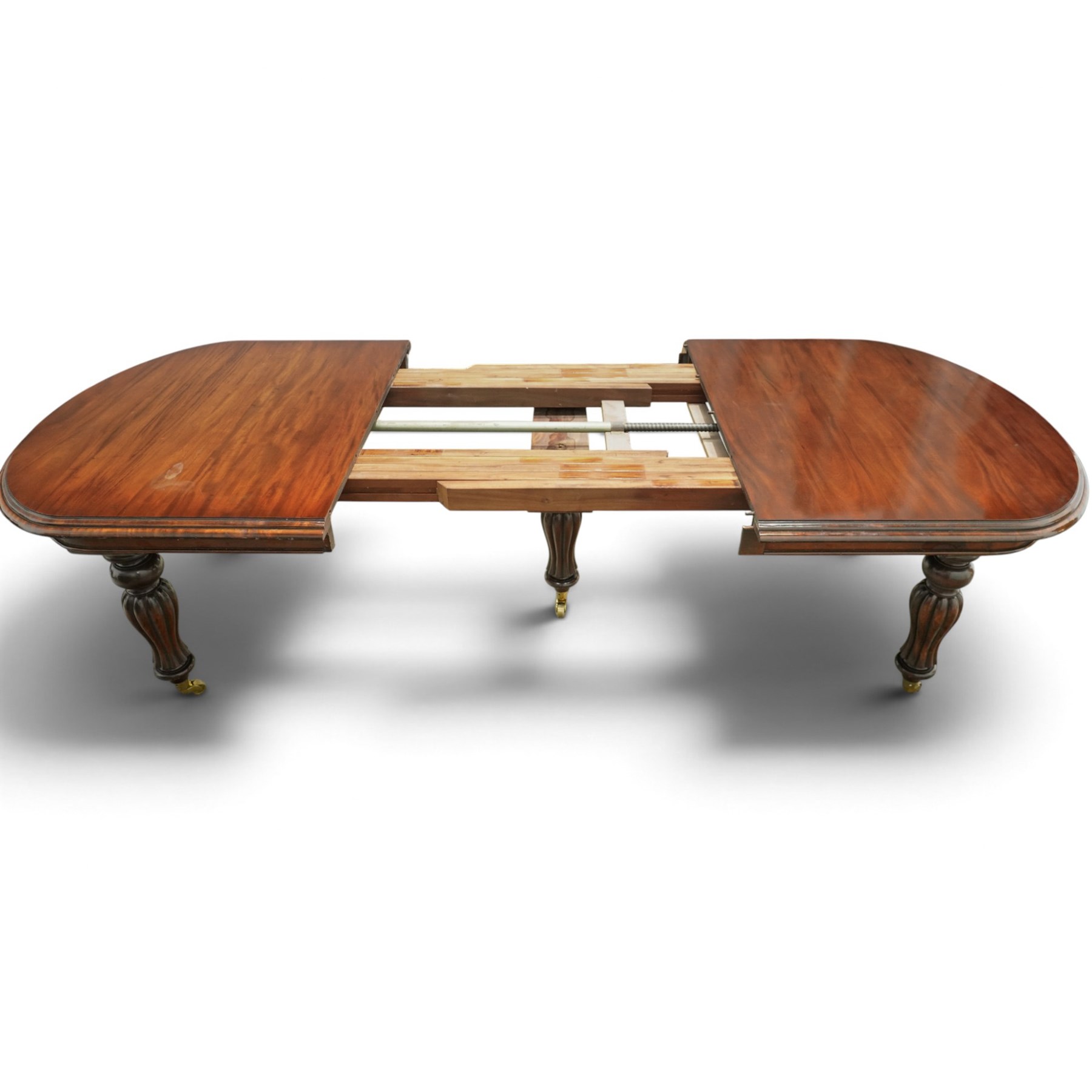 Large Victorian Country House mahogany extending dining table, the oval top with moulded edge over a plain frieze, raised on five large turned and reeded supports, with winding extending mechanism and additional leaf