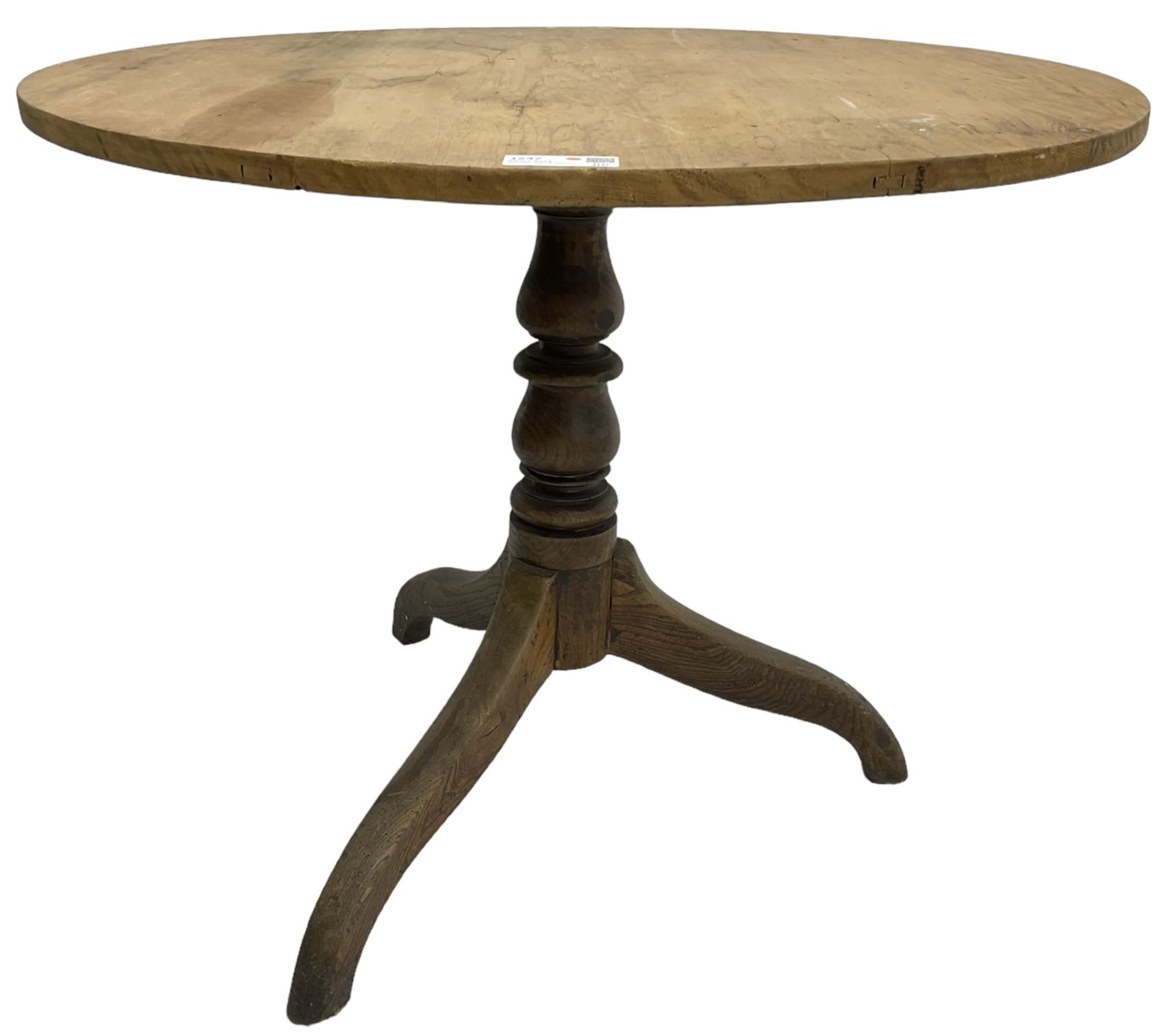 Early 19th century pine and elm tripod table; circular tilt-top over turned column and three splayed supports
