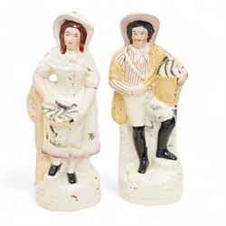 Staffordshire pottery figures including watch stand with piper and companion, pair of dogs and pups, pair of fish sellers and two others