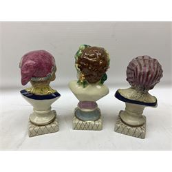 19th century pair of hand painted ceramic busts of children, together with a third similar example of a putti with a crown of ivy, tallest H23cm 