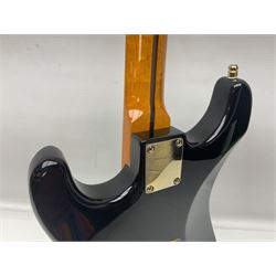 Copy of a Fender Stratocaster electric guitar in black with Wilkinson bridge, lock-in tuners, synchronised tremolo and various patent numbers; L99cm; in hard carrying case with strap and digital tuner