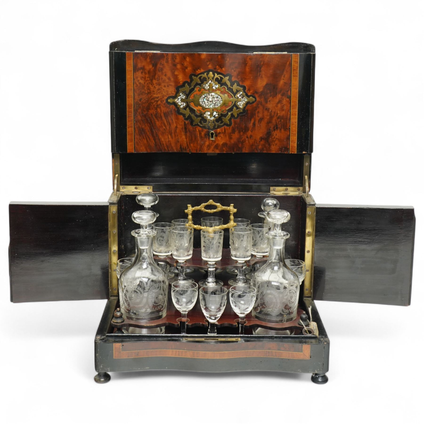 19th century French Boulle-style cave à liqueur or travelling decanter set, with musical mechanism playing carrara bonne de ay and Locked in the old Kent Road, the walnut box of serpentine front, the hinged lid with central brass and mother of pearl cartouche, with removable wooden tiered tray with gilt metal handle, containing four foliate etched glass decanters and sixteen glasses, H27cm