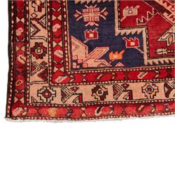 North West Persian runner, the indigo field decorated with three stepped cruciform medallions alternating with two octagonal panels, interspersed with stylised flowerheads and foliage, enclosed by an ivory ground floral border and red guard bands