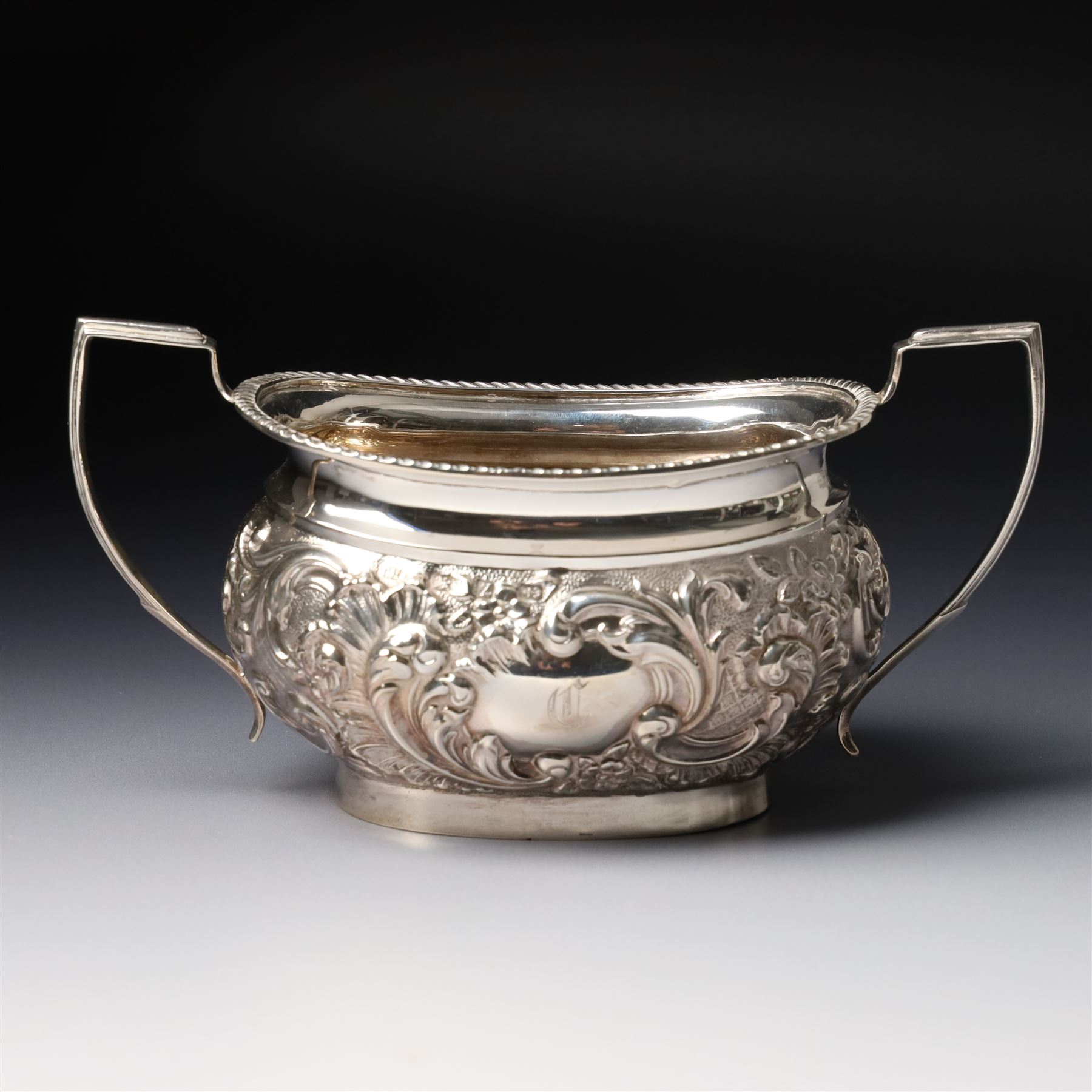 Late Victorian four piece silver tea set comprising teapot, coffee pot, sugar bowl and milk jug with embossed decoration, the cartouches engraved with an initial, the teapot and coffee pot Chester 1899 Maker George Nathan & Ridley Hayes, the sugar bowl and milk jug Birmingham 1899 Maker Thomas Hayes