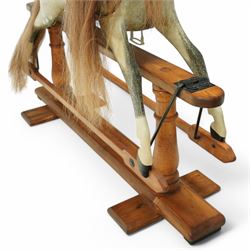 Frederick Henry Ayres (F H Ayres, London) - Late Victorian large carved wooden rocking horse, in dapple grey paint finish, decorated with glass eyes, leather reins, stirrup and saddle, indented hooves, on rockers united by chamfered stretchers and boarded base, c.1890