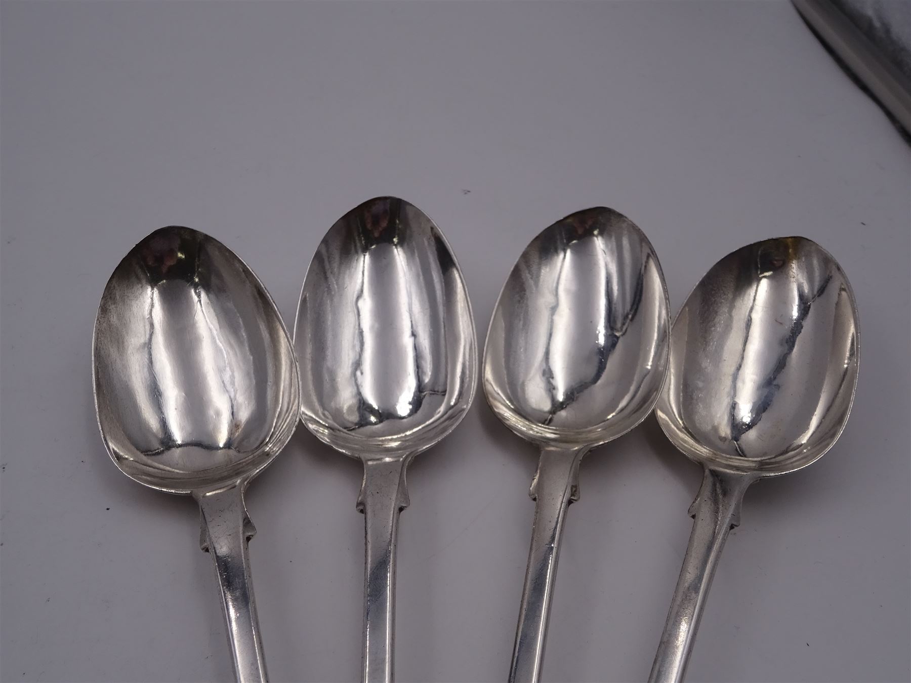 Group of Victorian silver fiddle pattern spoons, comprising pair of sauce ladles and set of six teaspoons, both hallmarked Henry Holland (of Holland, Aldwinckle & Slater), London 1857, set of four table spoons, hallmarked Chawner & Co (George William Adams), London 1857, and set of six dessert spoons, hallmarked Chawner & Co (George William Adams), London 1856, with monogrammed terminals, approximate total silver weight 25.50 ozt (792.6 grams)
